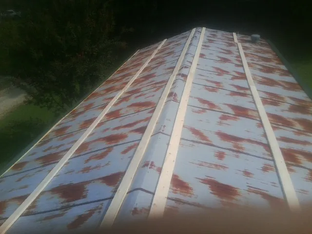 Rusted metal roof panels with new wood purlins before replacement — Storm Damage Roof Repair in Pine City by Roofing Brothers